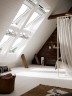 Schlafzimmer mit 4er-Fensterlösung VELUX INTEGRA Elektro- oder Solarfenster in Kunststoff mit Jalousetten.